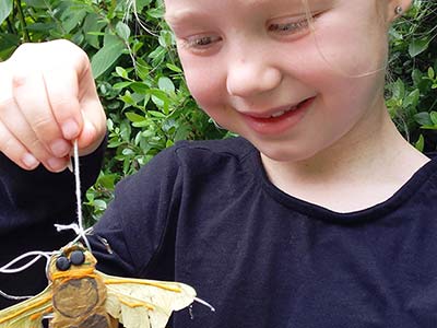 A child holding a craft bee