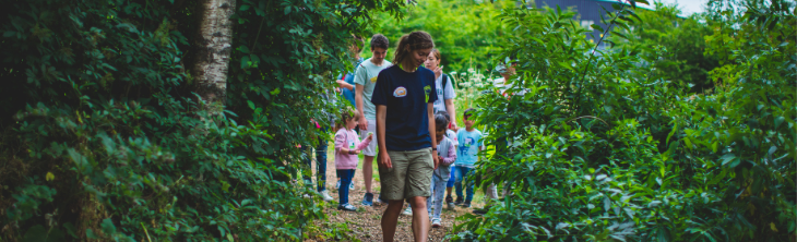 TCV volunteer guiding kids round a garden