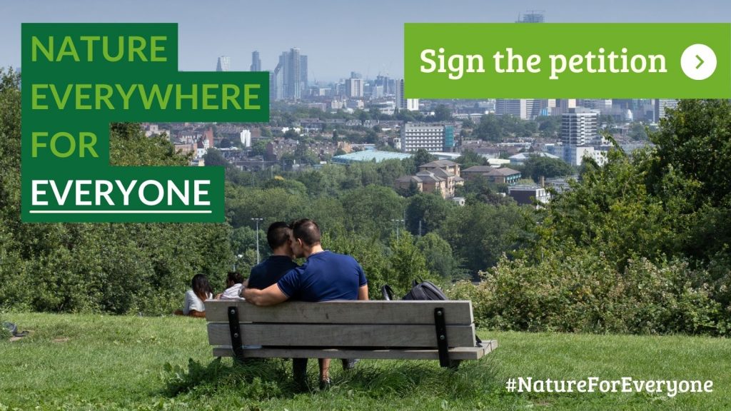 Two people sat on a bench with a city on the background. The photo includes the words Nature everywhere for everyone and asks the reader to the sign the petition