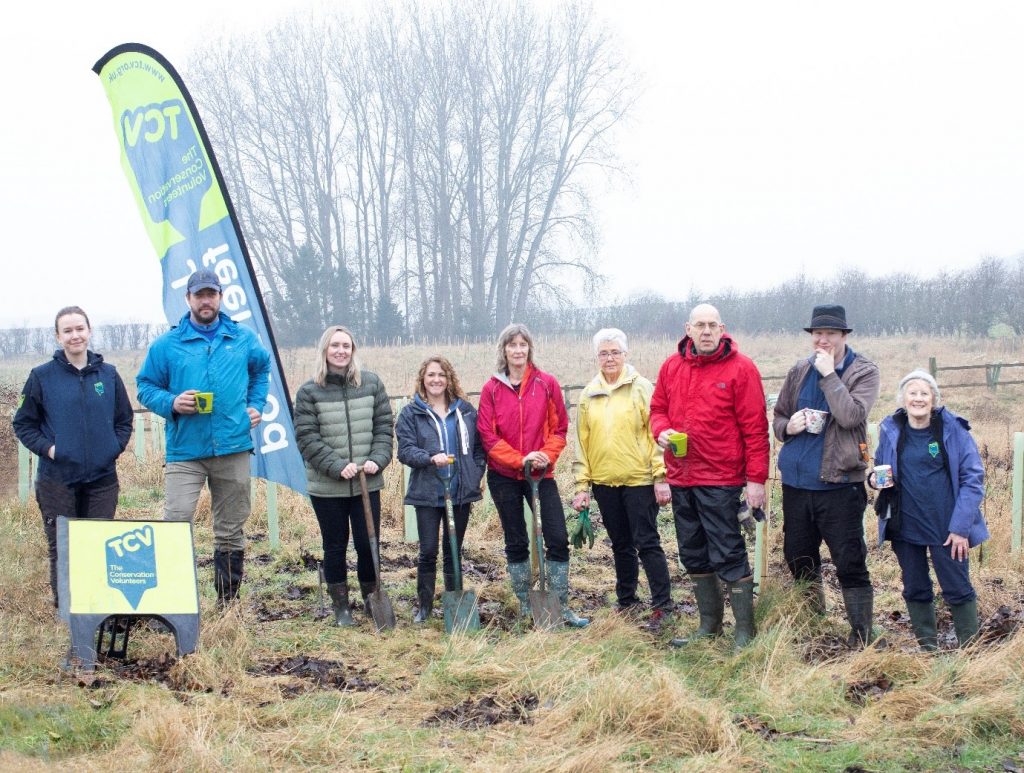 Centre: Sue Paver with Volunteers from Pavers Head Office, and The Conservation Volunteers facing the camera, some with cups of tea in their hands, in a grassy area.