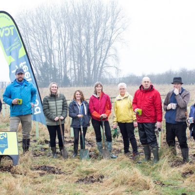 Centre: Sue Paver with Volunteers from Pavers Head Office, and The Conservation Volunteers facing the camera, some with cups of tea in their hands, in a grassy area.