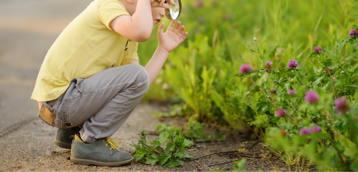 Child using magnifying glass, looking for clues