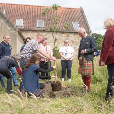 King Charles III plants a tree with TCV volunteers at Kinneil House and Estate.