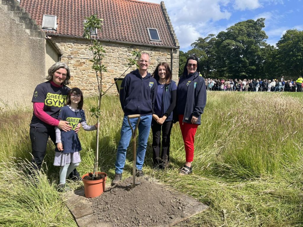 Group of TCV volunteers and TCV Chair with the tree planted by King Charles III at Kinneil House and Estate
