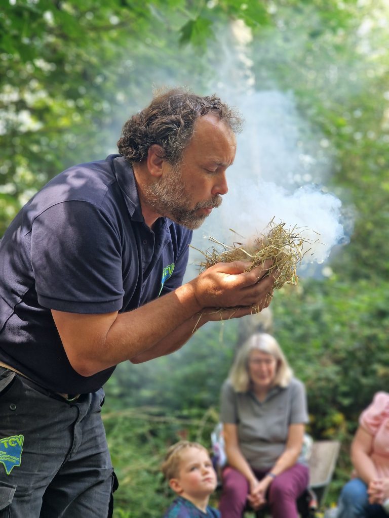 Man blowing kindling to start a fire