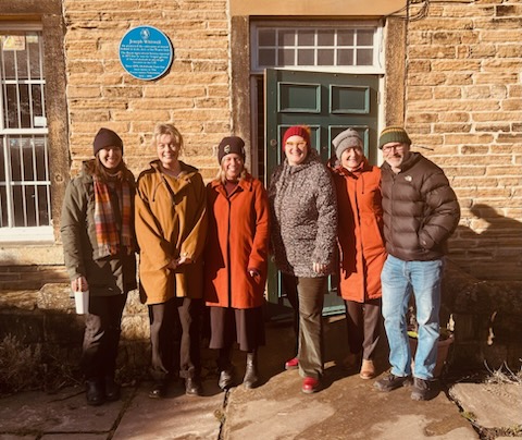 Group of people in winter clothing outside old building