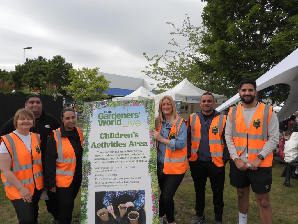 Group of people in orange high viz vests at Gardener's World Live.