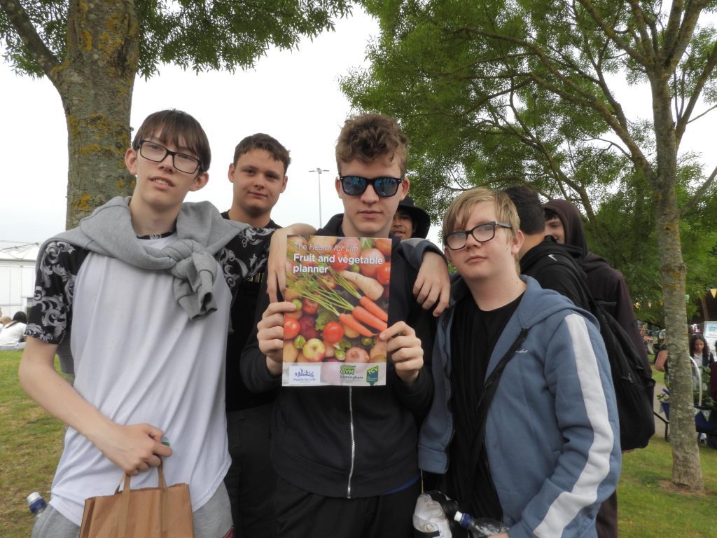Group of teenage boys holding a booklet about growing food