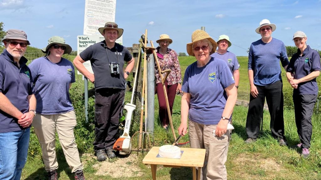 Group of TCV nature volunteers in a field wearing summer hats